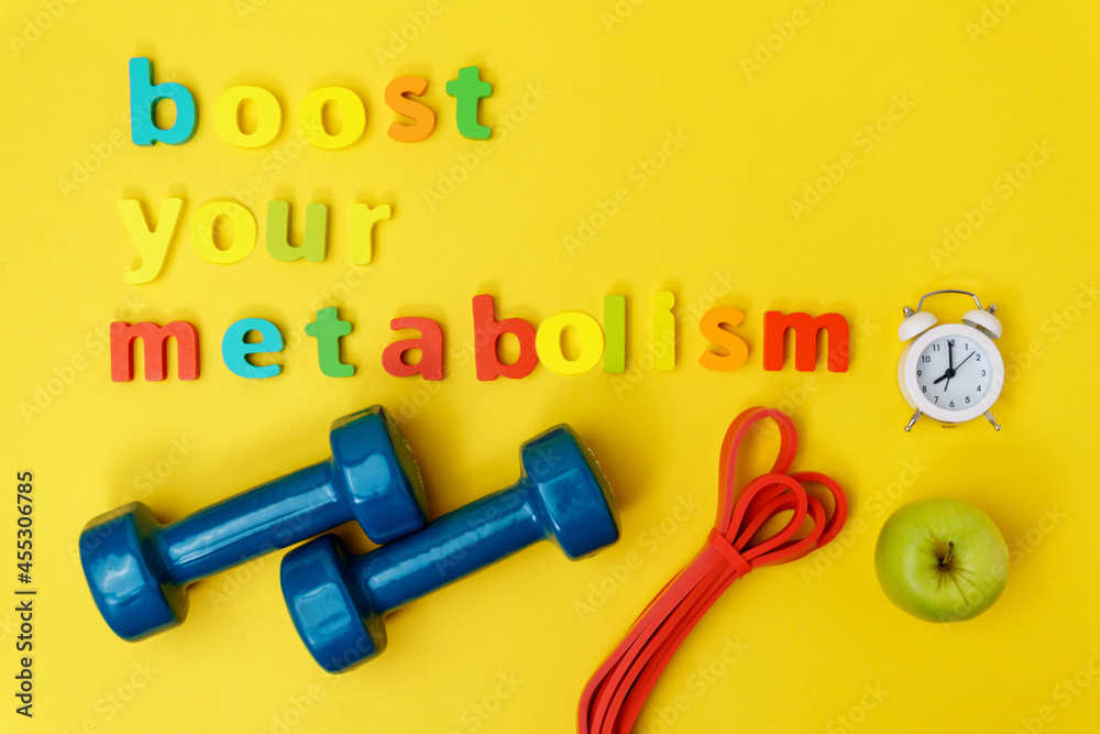 Boost your metabolism sports, dumbbells, apple on a yellow background top view. Boost your metabolism sports, dumbbells, apple on a yellow background top view.
