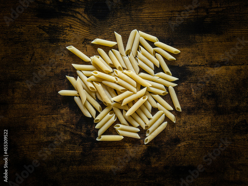 Des pâtes Penne sur une table de cuisine en bois photo