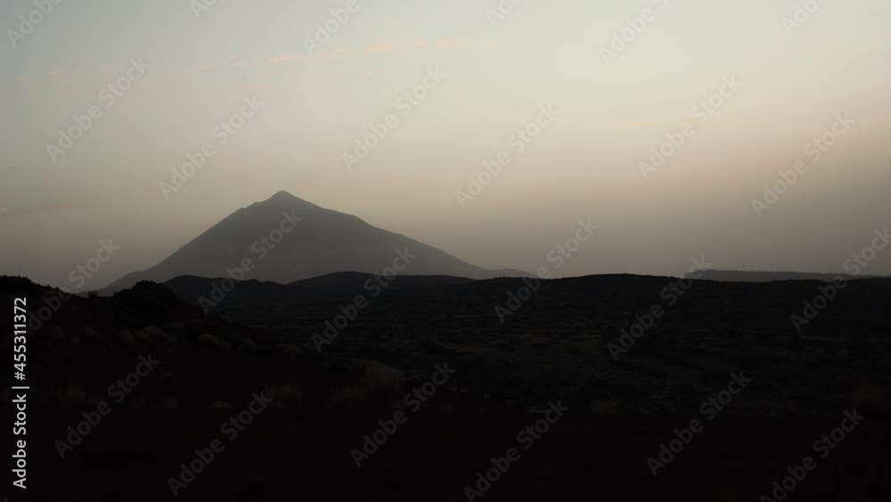 Time-lapse shot of beautiful white clouds covering mountain and desert abandoned volcanic landscape. Sunset in timelapse cinematic clip. Time-lapse shot of beautiful white clouds covering mountain and desert abandoned volcanic landscape. Sunset in timelapse cinematic clip.