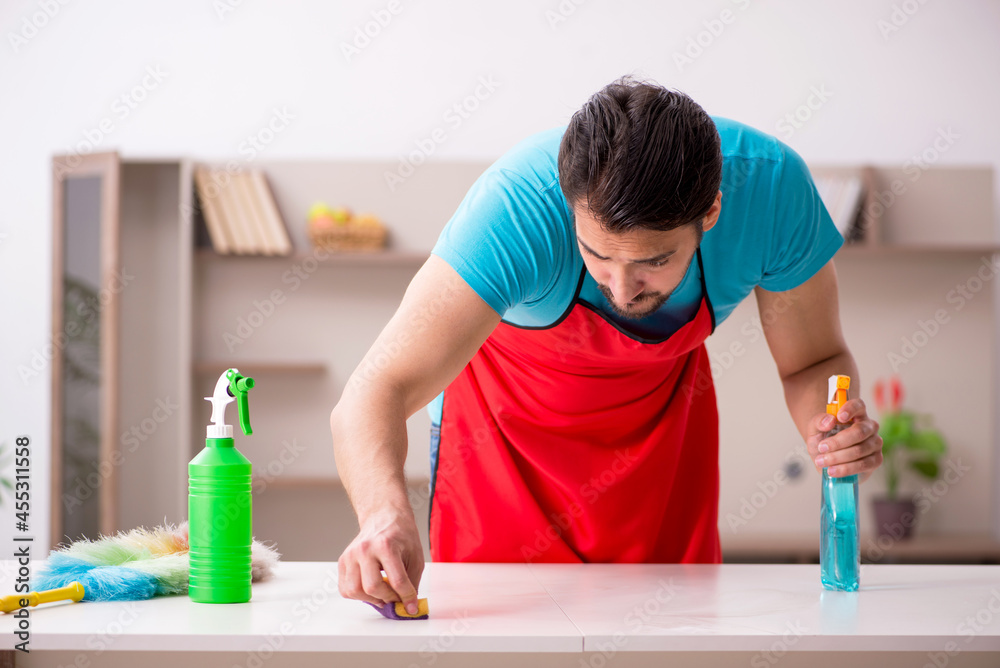 Young male contractor cleaning the house Young male contractor cleaning the house