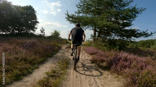 Man riding his mountain bike MTB on beautiful trail purple heathland during summer action sports lifestyle extreme cycling