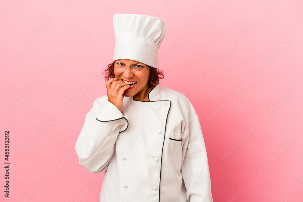 Middle age latin woman isolated on pink background biting fingernails, nervous and very anxious. Middle age latin woman isolated on pink background biting fingernails, nervous and very anxious.