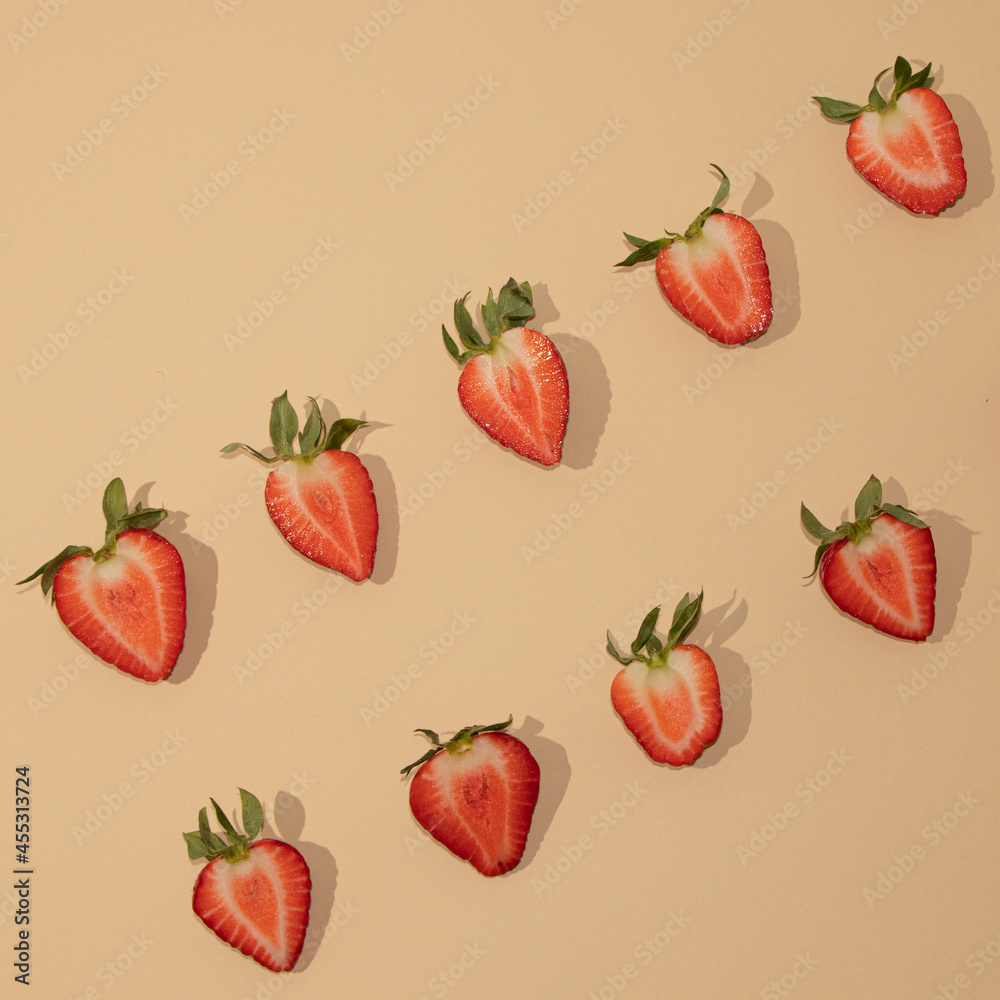 Symmetrically arranged tropical fruit and leaves, with half strawberry on beige background. Minimal flat lay Symmetrically arranged tropical fruit and leaves, with half strawberry on beige background. Minimal flat lay