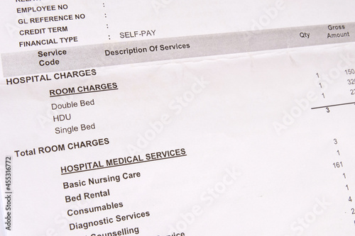 A hospital bill showing itemized charges for medical services used during hospitalization. A statement listing patient's medical treatment and healthcare expenses during a hospital stay. Closeup view. photo