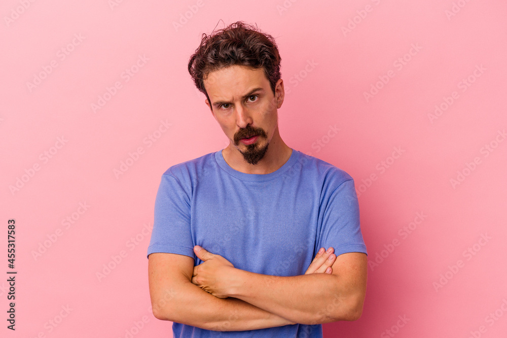 Young caucasian man isolated on pink background who is bored, fatigued and need a relax day. Young caucasian man isolated on pink background who is bored, fatigued and need a relax day.