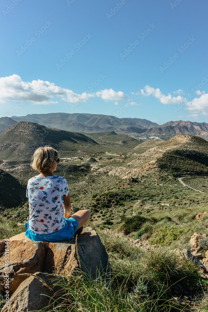 Female solo traveler enjoying views of Cabo de Gata Nature Reserve,Andalusia,Spain.Protected coastal area with wild isolated landscape and volcanic rock formations.Travel inspiration freedom scenery.