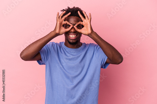 Young african american man isolated on pink background excited keeping ok gesture on eye.