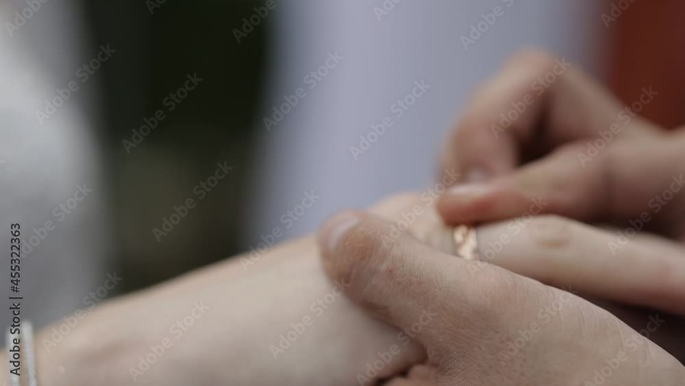 the groom puts on the bride's wedding ring, a close plan the groom puts on the bride's wedding ring, a close plan
