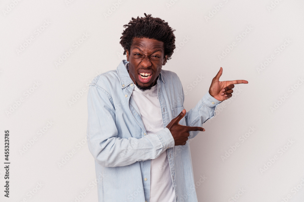 Young african american man isolated on white background pointing with forefingers to a copy space, expressing excitement and desire. Young african american man isolated on white background pointing with forefingers to a copy space, expressing excitement and desire.