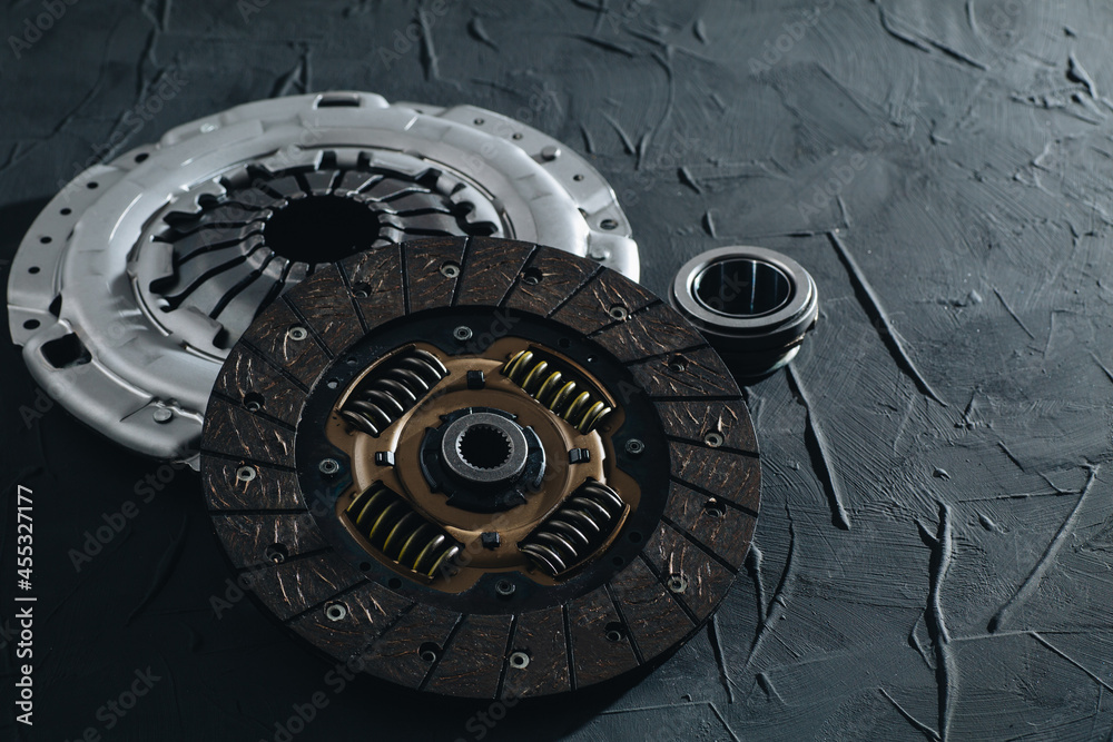 Automotive clutch mechanism, disc, basket and bearing for auto on a black background.