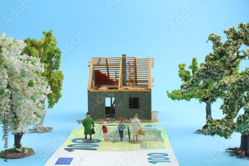 kleines Plastikhaus mit Figuren einer Familie im Vordergrund  photo