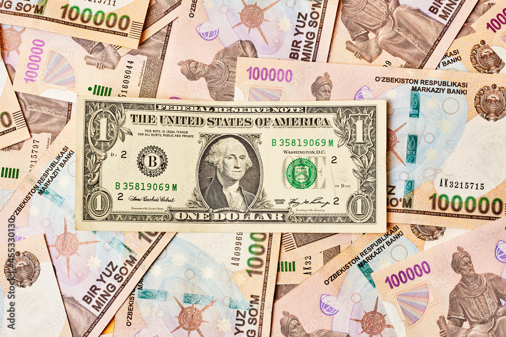 US dollar banknote and Uzbek sums. Concept of exchange rate, Uzbek sum to us dollar. Money exchange in Uzbekistan. Pile of Uzbek money sum and American dollar bill US dollar banknote and Uzbek sums. Concept of exchange rate, Uzbek sum to us dollar. Money exchange in Uzbekistan. Pile of Uzbek money sum and American dollar bill