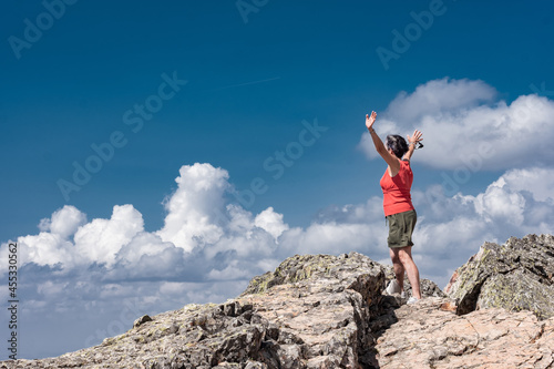 Woman  looking down on the valley from a mountain top