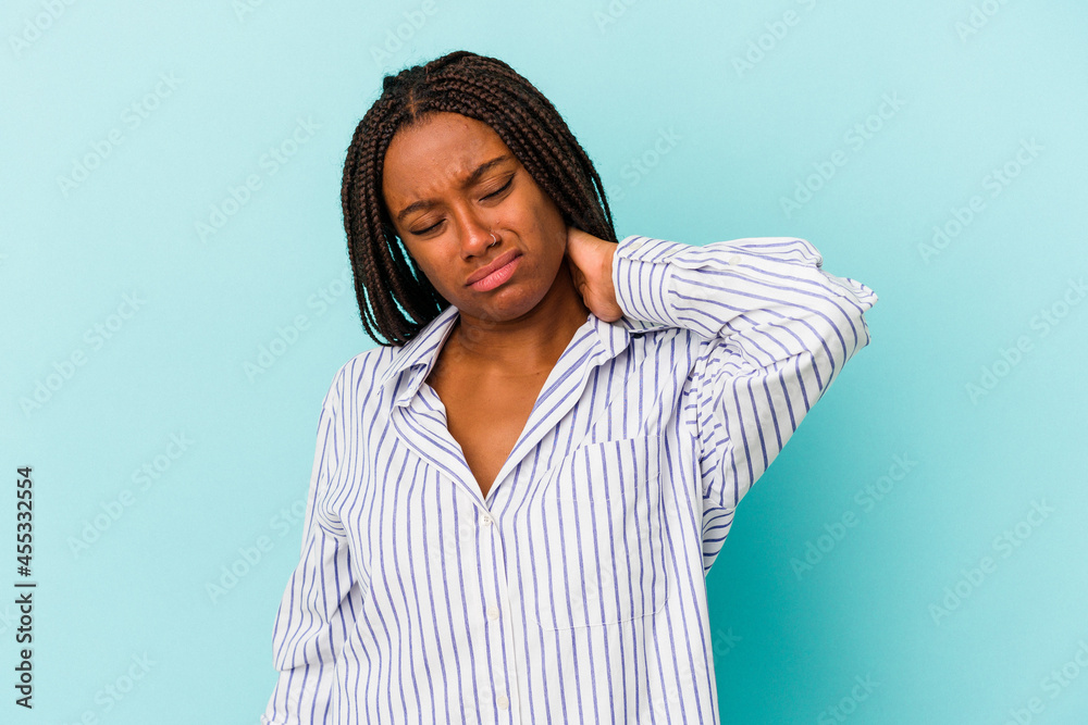 Fototapeta premium Young african american woman isolated on blue background having a neck pain due to stress, massaging and touching it with hand.
