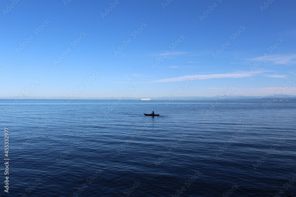 kleines Kajak im Meer mit blauem Himmel 