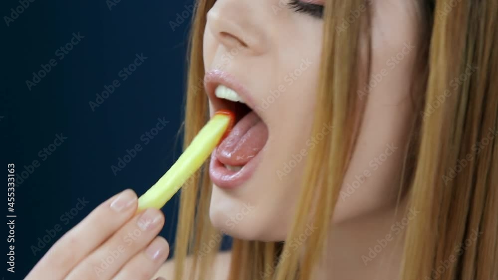 Close-up face of a cute girl eating fries. Close-up face of a cute girl eating fries.