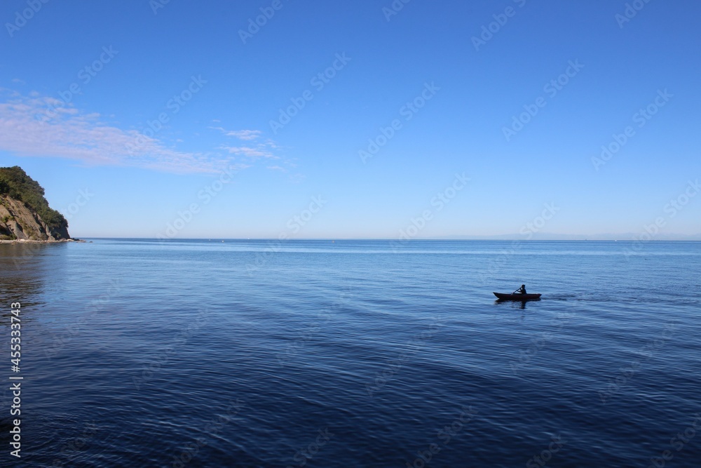 kleines Kajak im Meer mit blauem Himmel 