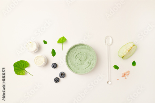 Cosmetic glass bottle, jar with nature eco cream and moisturizer tube with herbal ingredients on white surface