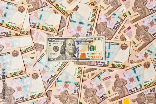 US dollar banknote and Uzbek sums. Concept of exchange rate  Uzbek sum to us dollar. Money exchange in Uzbekistan. Pile of Uzbek money sum and American dollar bill