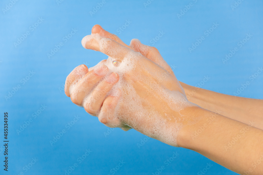 Persona lavándose las manos, desinfección de manos. Fondo azul Persona lavándose las manos, desinfección de manos. Fondo azul