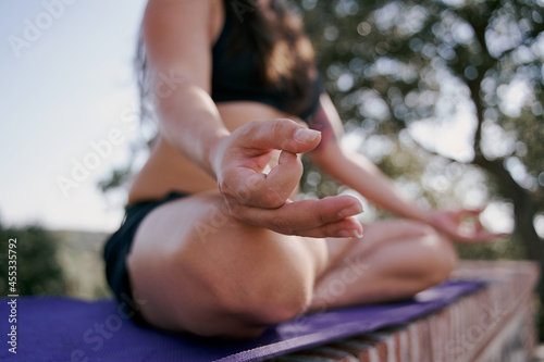 Close-up hand of a woman doing yoda outdoors. Woman doing meditation exercise in the background of nature, select focus.