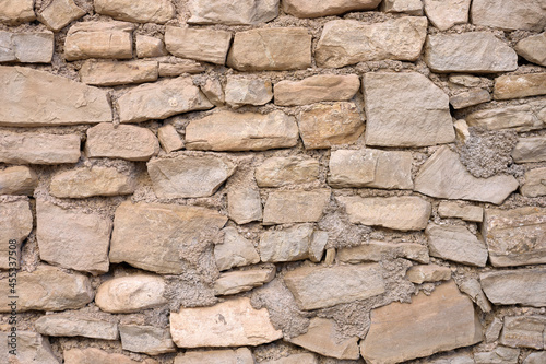 old iregular stone wall with mortar photo