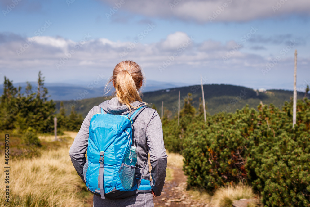 Woman with backpack hiking in mountains. Travel active lifestyle and adventure concept. Mountain trek