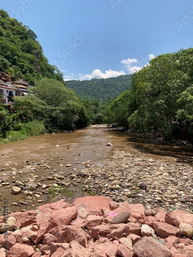 Río con piedras y montañas verdes al fondo