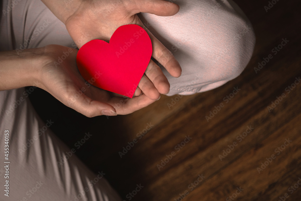 Hands giving red heart. Concept of giving love. Healthcare, life insurance, mental health banner. Black background, banner with copy space photo Hands giving red heart. Concept of giving love. Healthcare, life insurance, mental health banner. Black background, banner with copy space photo