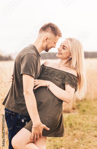 A young couple, a man and a woman look at each other with love in the summer in nature