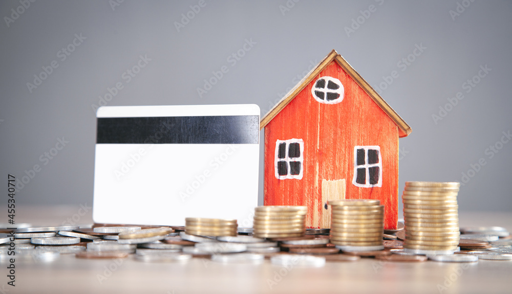 House model,coins and credit card on the wooden table. House model,coins and credit card on the wooden table.