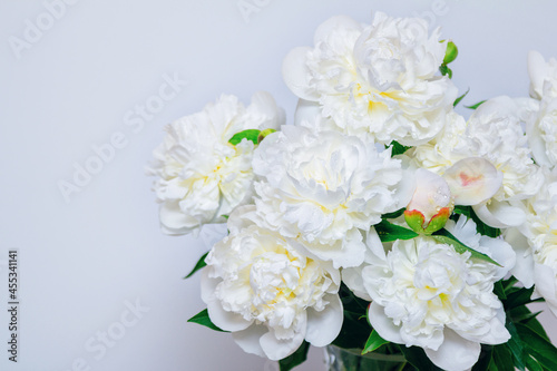 Beautiful white peony flowers bouquet with water drops on petals on a white background.