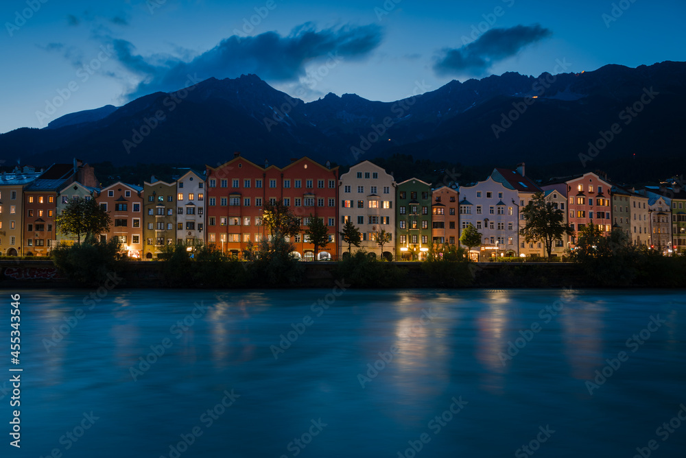 Colored houses on the Inn river with the mountains in the background at night, Tyrol, Innsbruck, Austria