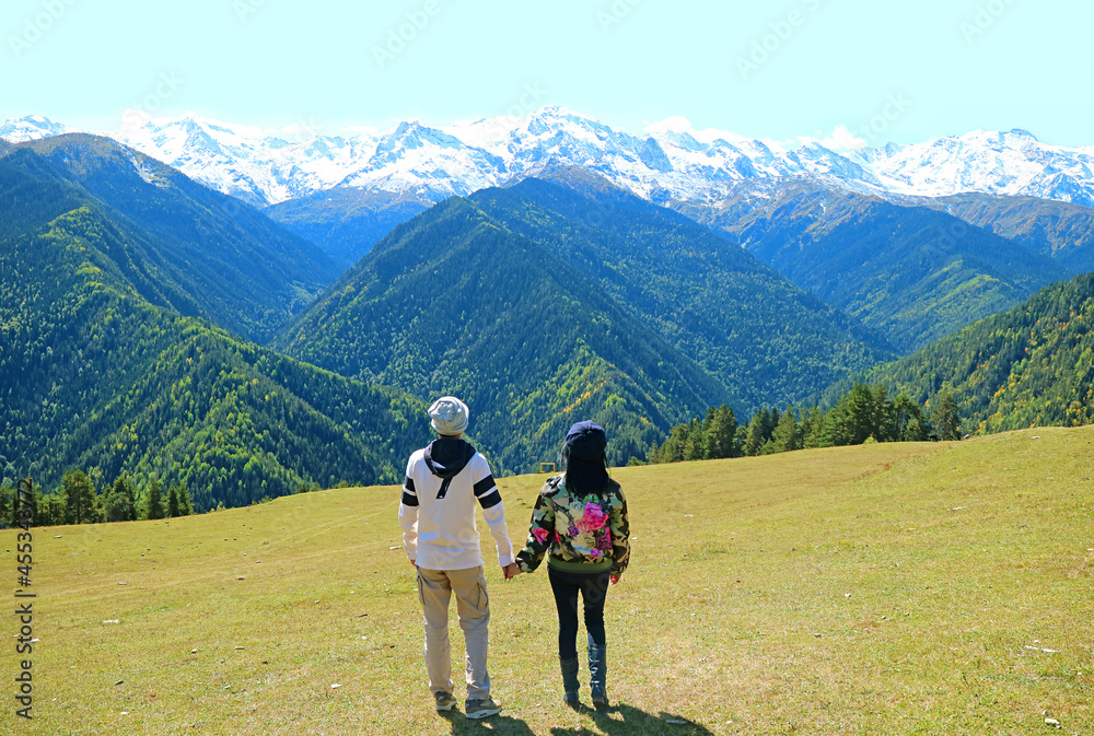 Couple Enjoy the Amazing View of the Caucasus Mountain Ranges, Mestia, Svaneti Region, Georgia Couple Enjoy the Amazing View of the Caucasus Mountain Ranges, Mestia, Svaneti Region, Georgia