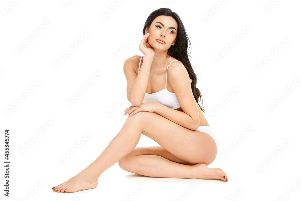 Fitness young woman with a beautiful body sitting on white background Fitness young woman with a beautiful body sitting on white background