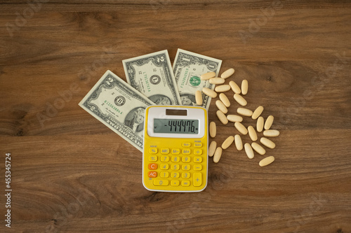 Billede på lærred money, pills and calculator on a wooden background
