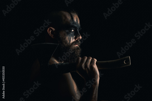 Viking warrior with black war paint, holding his axe.