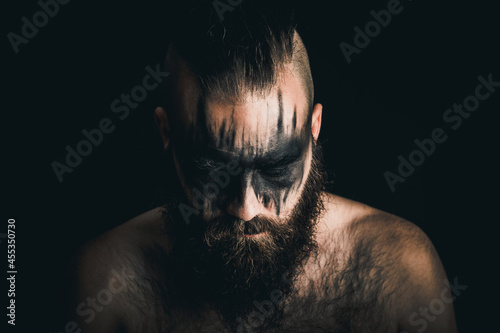 Obraz na płótnie Viking warrior with black war paint looking down in despair and defeat