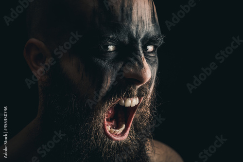 Canvas Print Portrait of a Viking warrior with black war paint, screaming with rage and anger