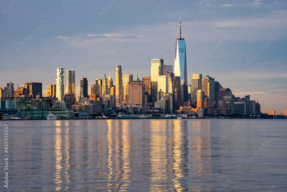 New York, NY - USA - Sept. 4, 2021: Landscape image of the skyline of Lower Manhattan at sunrise, with reflections seen in the Hudson River. Highlighting the World Trade  Center.