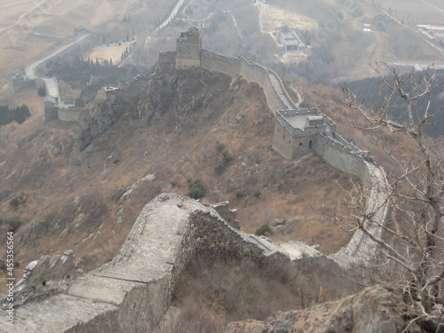 Great Wall at Jiaoshan like a snake creeps in the winter haze, near Shanhaiguan, China. photo