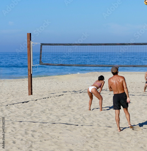 coed beach volleyball team preparing to return serve
