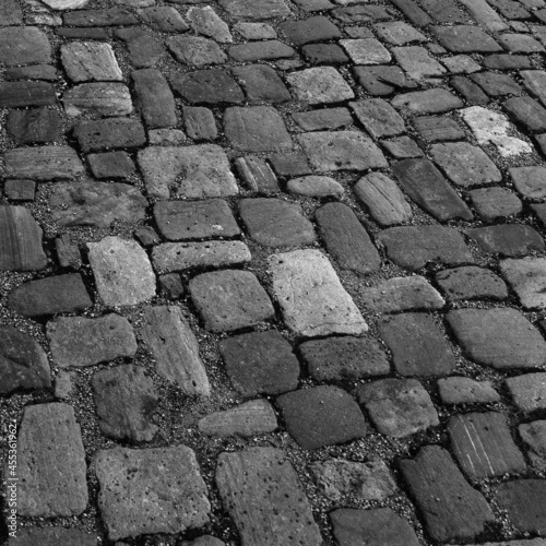Old cobblestone pavement. Stone vintage paved road. Brush basis black and white
