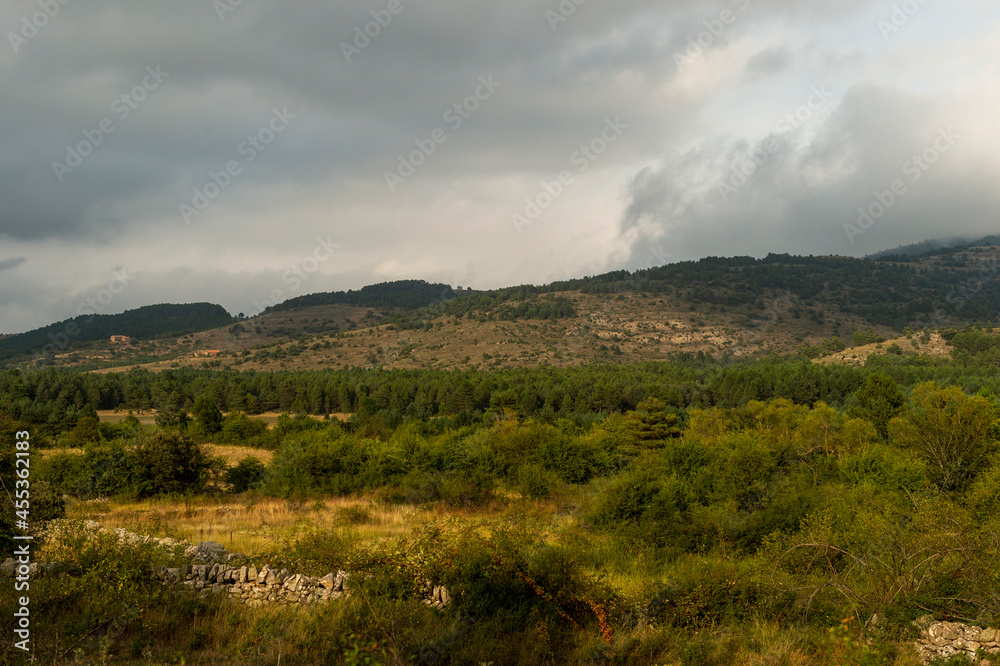 landscape of fields and mountains with clouds in the sky
