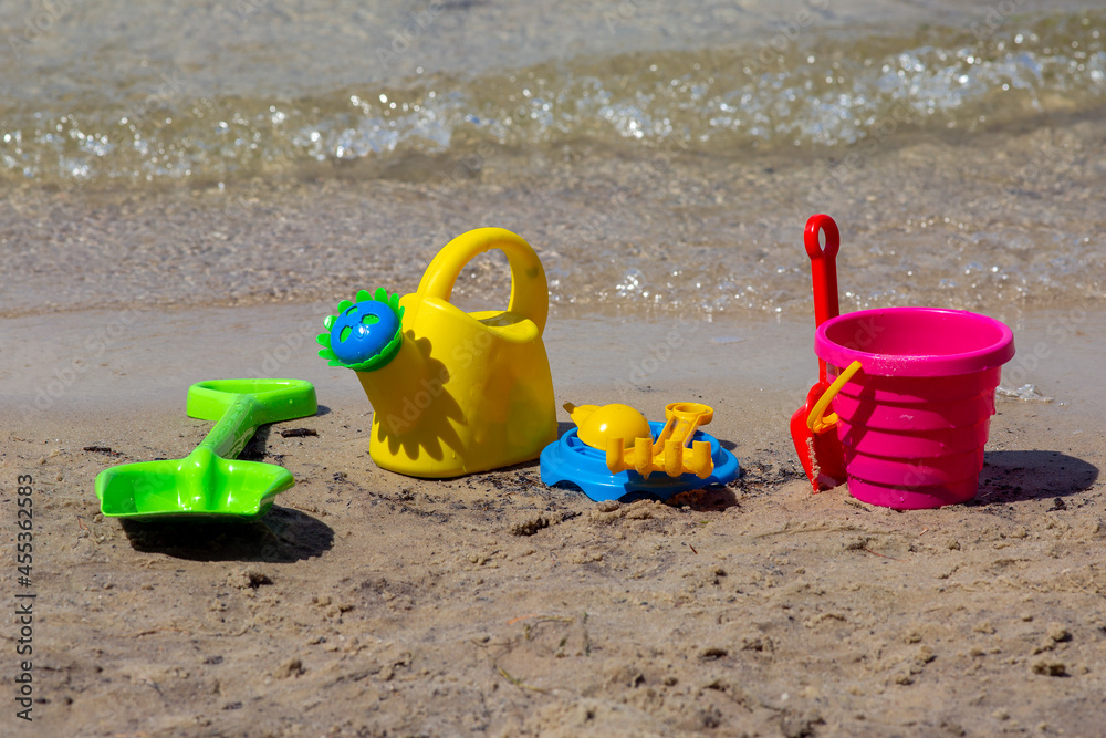 Multicolored children's toys on the beach. Children's vacation at sea. Multicolored children's toys on the beach. Children's vacation at sea.