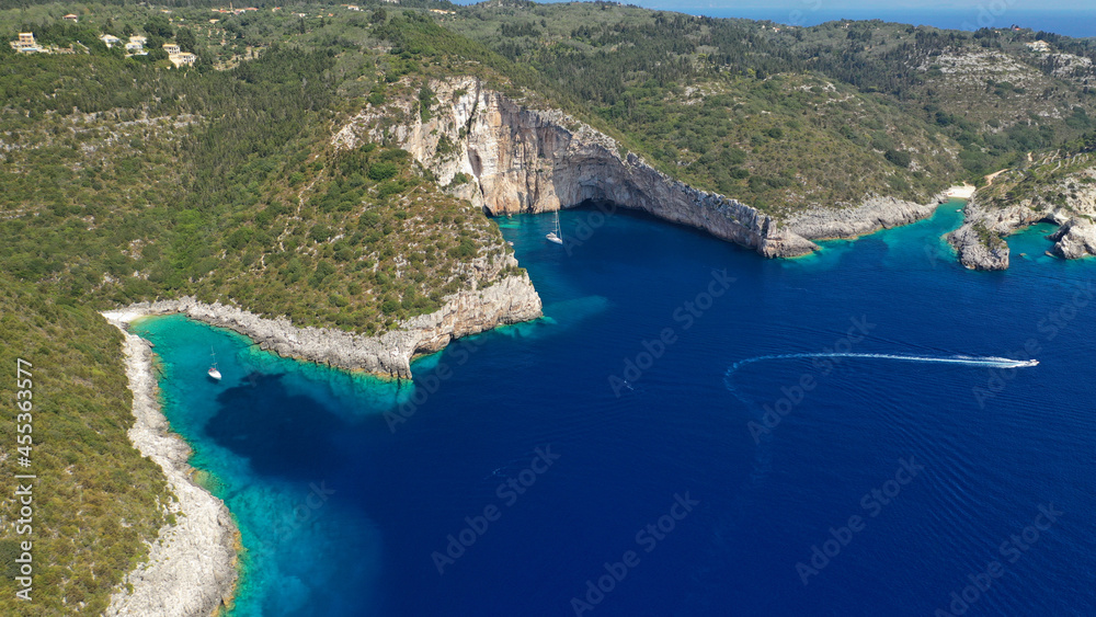 Aerial drone photo of tropical exotic paradise bay with deep turquoise sea and caves forming a blue lagoon visited by luxury yachts and sail boats