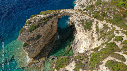 Aerial drone photo of scenic rock formation and natural arch of Tripitos over turquoise crystal clear Ionian sea, Paxos island, Greece