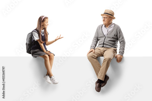 Schoolgirl sitting on a panel and talking to an elderly man