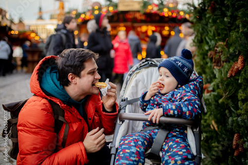 Father and son eating waffle at Christmas market