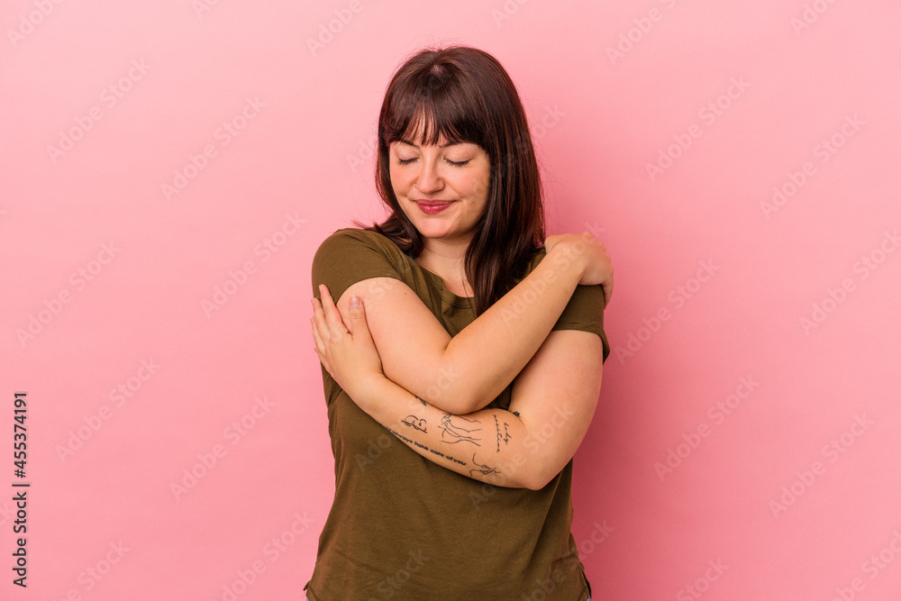 Young curvy caucasian woman isolated on pink background hugs, smiling carefree and happy. Young curvy caucasian woman isolated on pink background hugs, smiling carefree and happy.